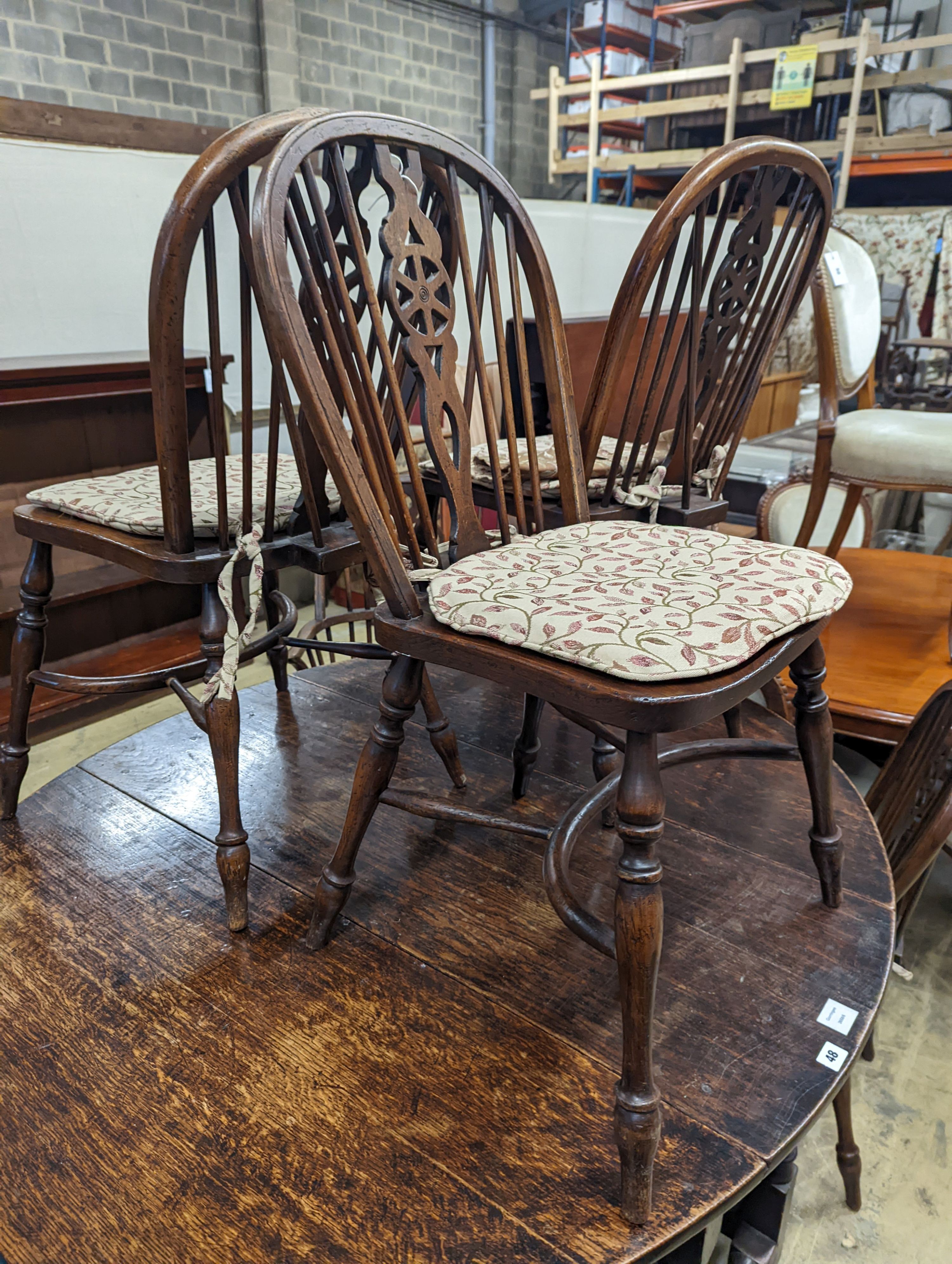 A wheelback Windsor elm and beech chair and six matching single chairs with crinoline stretchers, one with arms